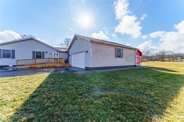 view of home's exterior featuring a wooden deck, a yard, an outdoor structure, and a garage