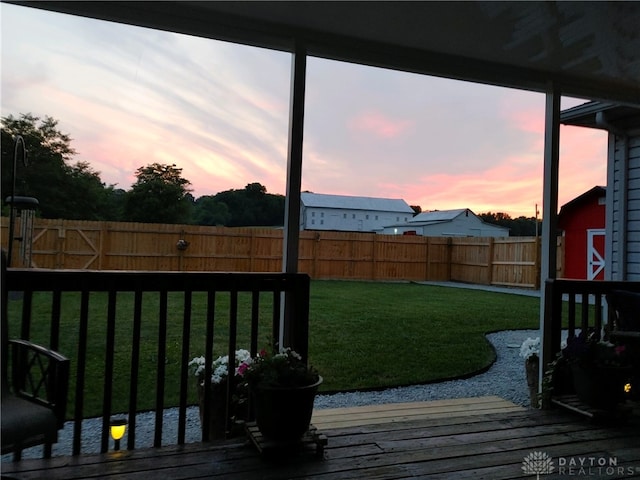 yard at dusk featuring a wooden deck