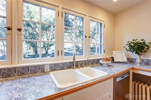 kitchen featuring tile countertops, radiator heating unit, dishwasher, white cabinetry, and sink