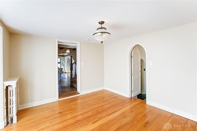 empty room featuring an inviting chandelier and wood-type flooring