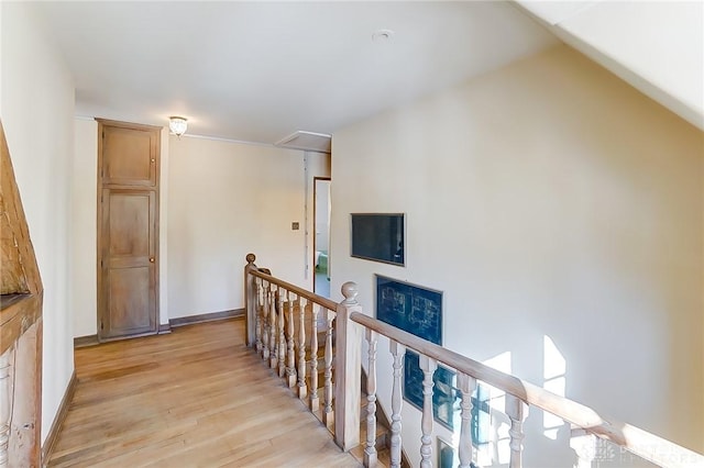 hall with vaulted ceiling and light hardwood / wood-style floors