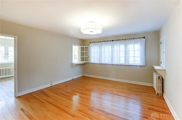 interior space with radiator heating unit and light hardwood / wood-style floors