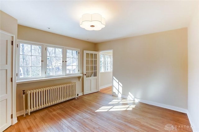 empty room featuring radiator and light wood-type flooring