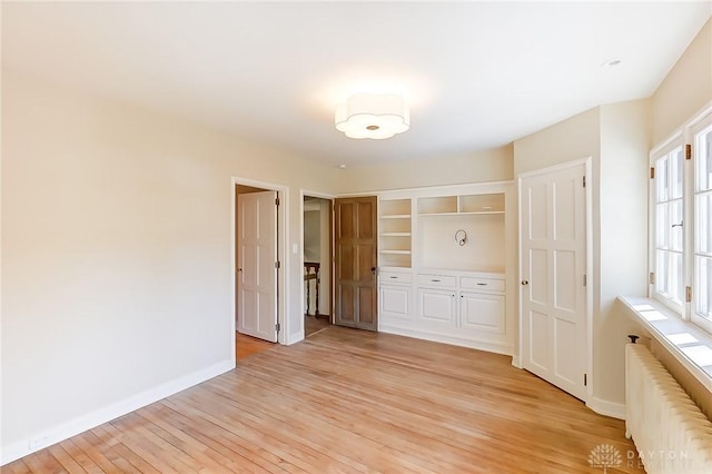 interior space with radiator heating unit and light hardwood / wood-style floors