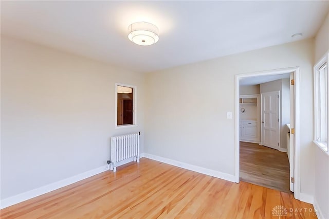 spare room with radiator and hardwood / wood-style flooring