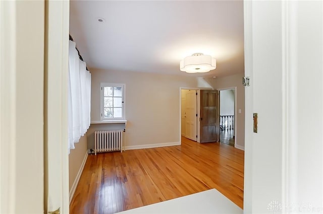 hallway with hardwood / wood-style flooring and radiator heating unit