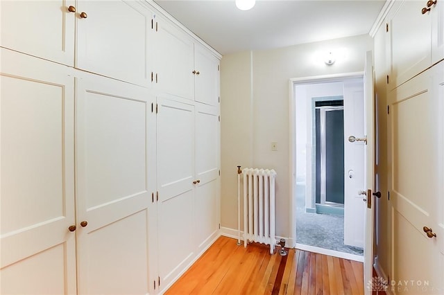 hall with radiator heating unit and light hardwood / wood-style floors