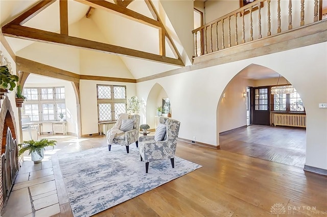 living room with radiator, hardwood / wood-style flooring, high vaulted ceiling, and beamed ceiling