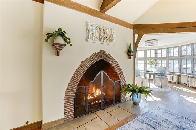 room details with beamed ceiling, radiator heating unit, a fireplace, and wood-type flooring