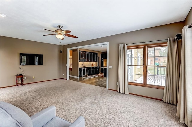 carpeted living room with ceiling fan