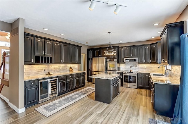 kitchen featuring a kitchen island, decorative light fixtures, sink, wine cooler, and stainless steel appliances