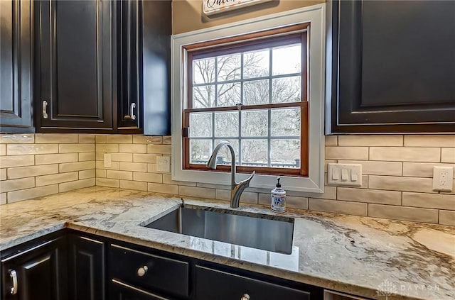 kitchen featuring a healthy amount of sunlight, light stone countertops, and sink