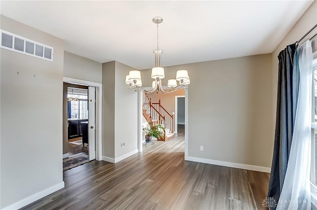 unfurnished dining area featuring dark hardwood / wood-style flooring and a chandelier