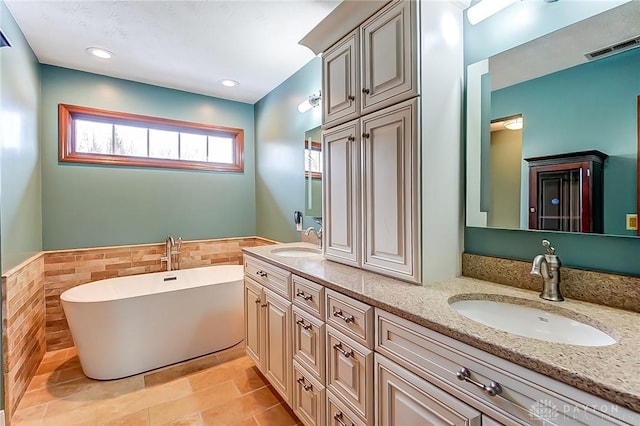 bathroom with a bathing tub, tile walls, and vanity