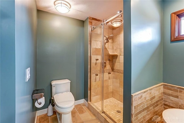 bathroom featuring toilet, tile patterned flooring, and a shower with door