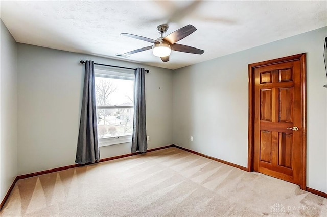 carpeted empty room with ceiling fan and a textured ceiling