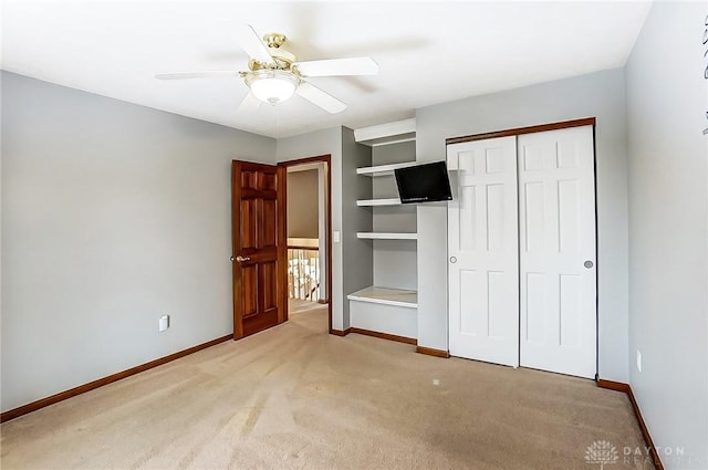 unfurnished bedroom featuring light carpet, a closet, and ceiling fan