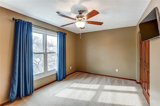 empty room featuring light colored carpet and ceiling fan