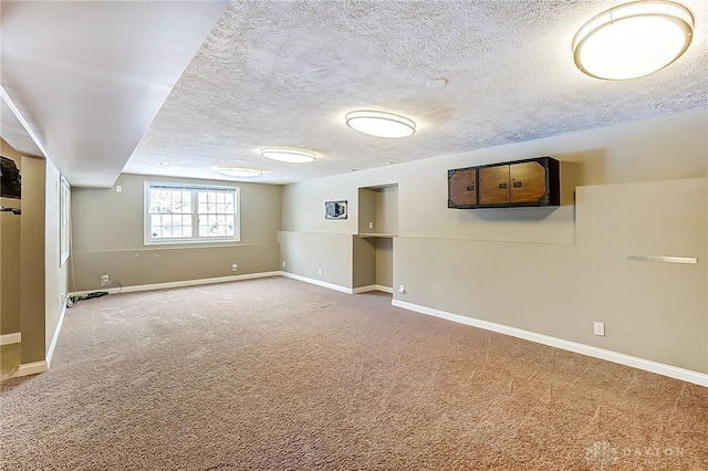 basement featuring a textured ceiling and carpet flooring