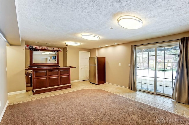 empty room with light carpet and a textured ceiling