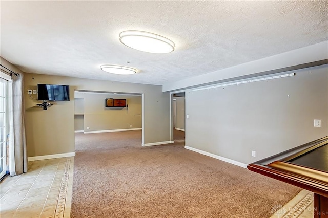 carpeted spare room featuring a textured ceiling