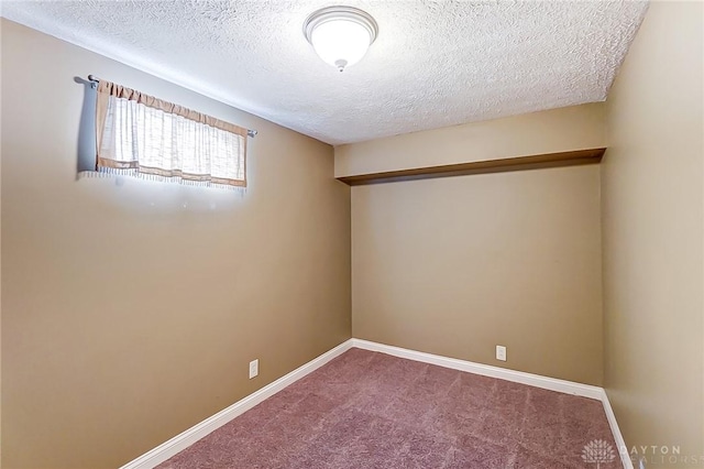 spare room featuring carpet flooring and a textured ceiling