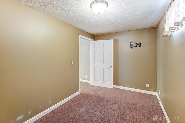 carpeted spare room with a textured ceiling