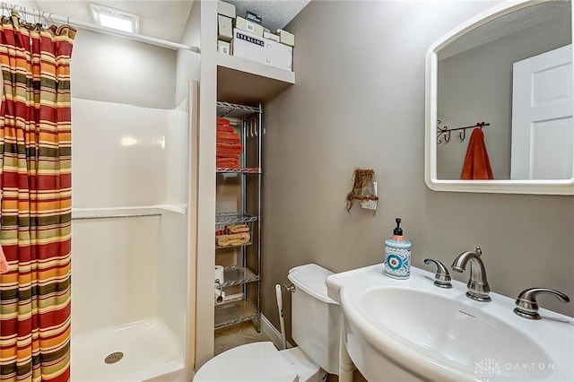 bathroom featuring sink, curtained shower, and toilet