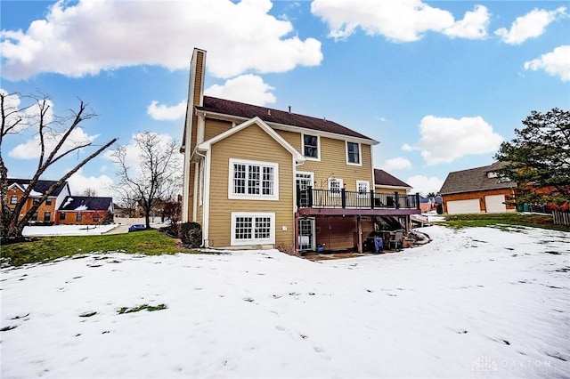 snow covered house featuring a wooden deck