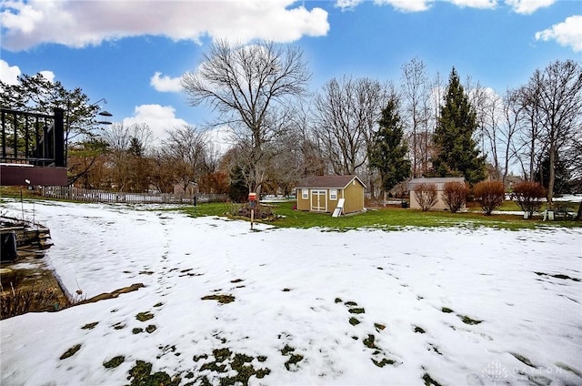 snowy yard with a shed