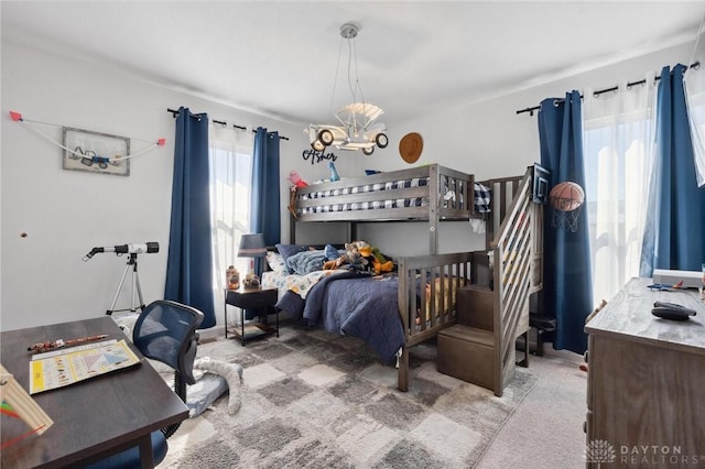 carpeted bedroom featuring a notable chandelier