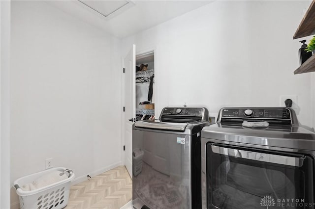 washroom with washer and clothes dryer and light parquet flooring