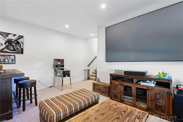 living area featuring recessed lighting, light carpet, baseboards, and stairs