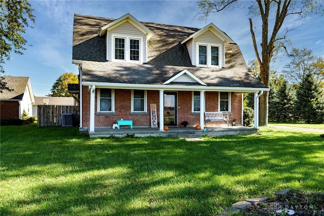 new england style home featuring central AC unit, a front yard, and covered porch