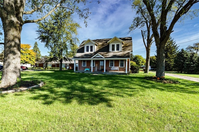 cape cod house featuring a porch and a front lawn