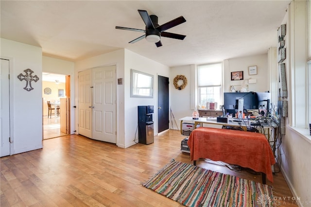 office with light hardwood / wood-style flooring and ceiling fan