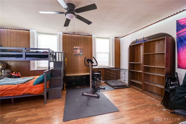 workout area with ceiling fan and light wood-type flooring