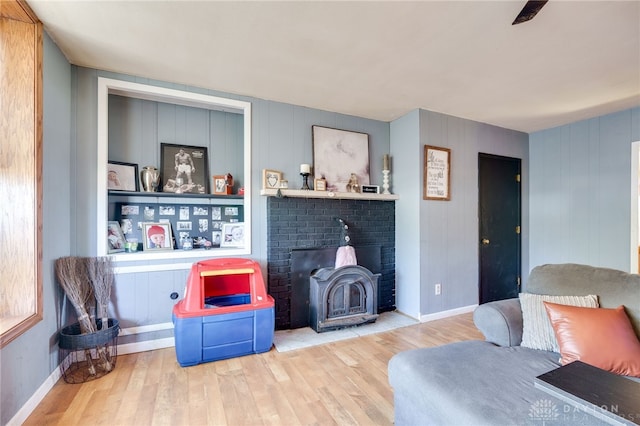 sitting room with hardwood / wood-style flooring and a wood stove