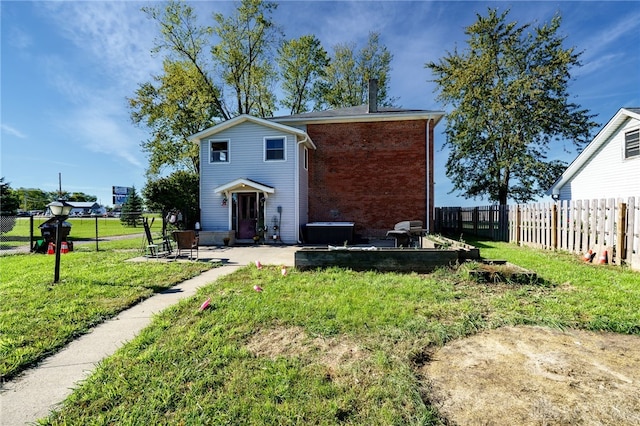 back of house featuring a patio and a yard