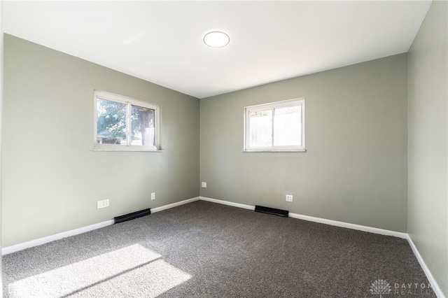 spare room featuring plenty of natural light and carpet