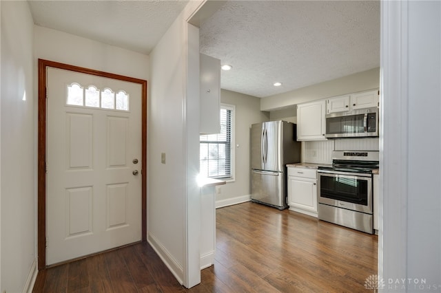 foyer entrance featuring dark wood-type flooring and a textured ceiling