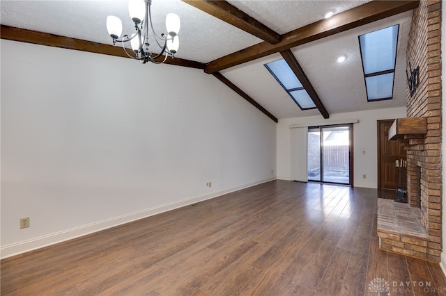 unfurnished living room with lofted ceiling with beams, a brick fireplace, a textured ceiling, dark hardwood / wood-style flooring, and a notable chandelier