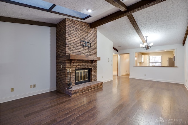 unfurnished living room featuring a fireplace, wood-type flooring, vaulted ceiling with beams, a chandelier, and a textured ceiling