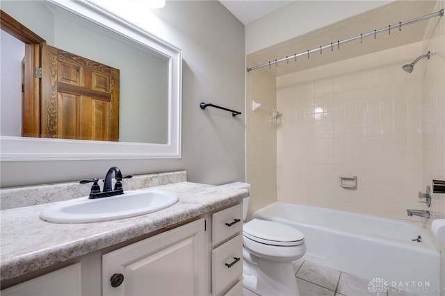 full bathroom with tiled shower / bath combo, vanity, tile patterned floors, and toilet