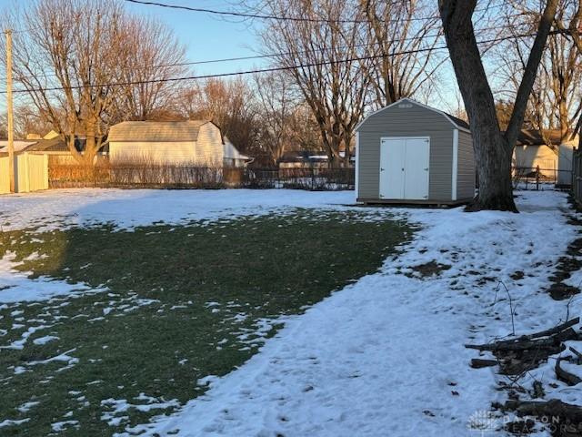 yard layered in snow featuring a shed