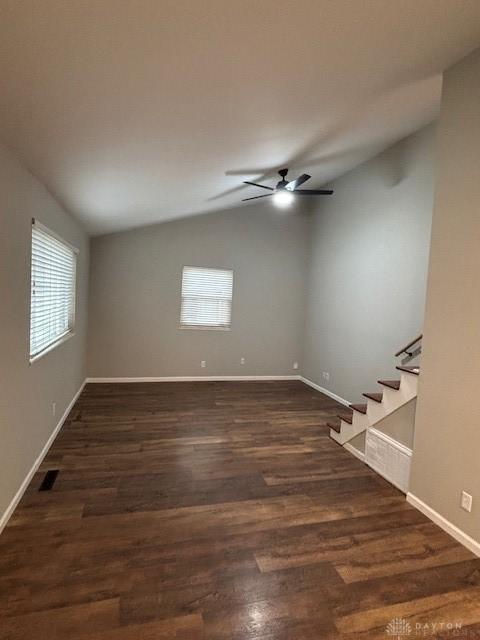 spare room featuring dark hardwood / wood-style flooring, vaulted ceiling, and ceiling fan