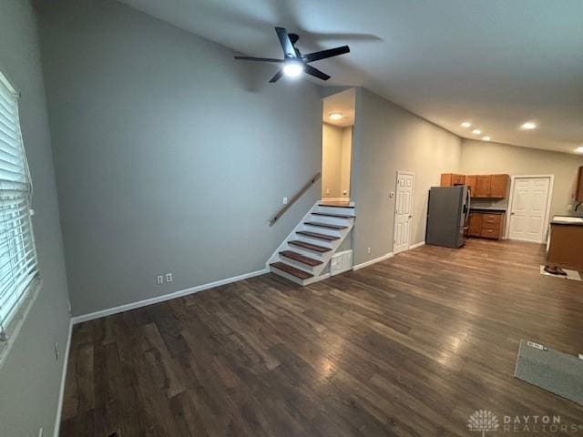 unfurnished living room featuring lofted ceiling, dark hardwood / wood-style floors, and ceiling fan