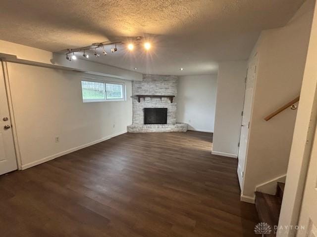 unfurnished living room featuring a fireplace, dark hardwood / wood-style floors, and a textured ceiling