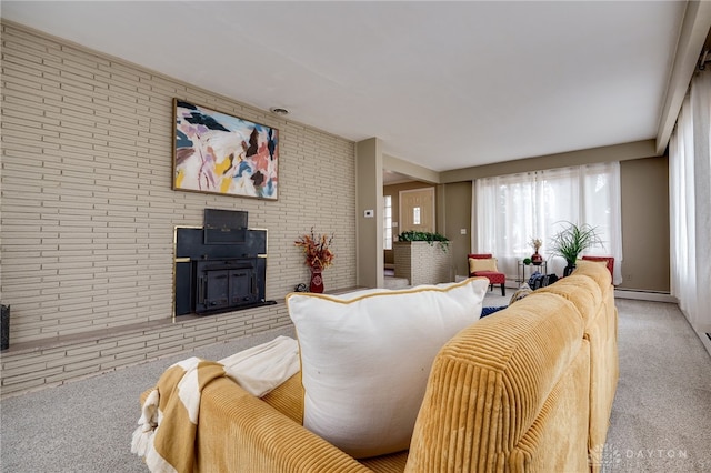 carpeted living room with baseboard heating, brick wall, and a wood stove