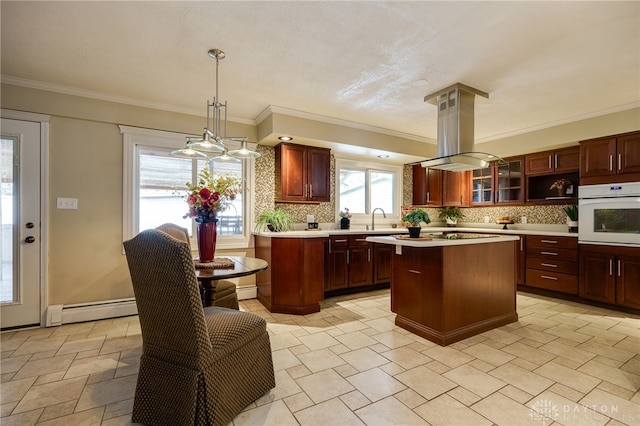 kitchen with island range hood, oven, hanging light fixtures, a baseboard heating unit, and a center island